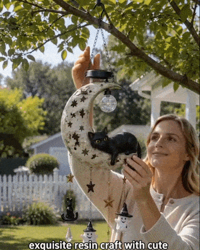 Solar black cat crescent moon hanging light glowing on a Halloween porch
