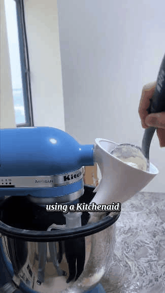 Stand mixer ingredient funnel guiding flour cleanly into the mixing bowl