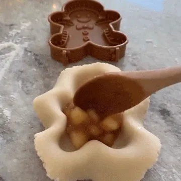 Using a hand press mold to shape Christmas dough