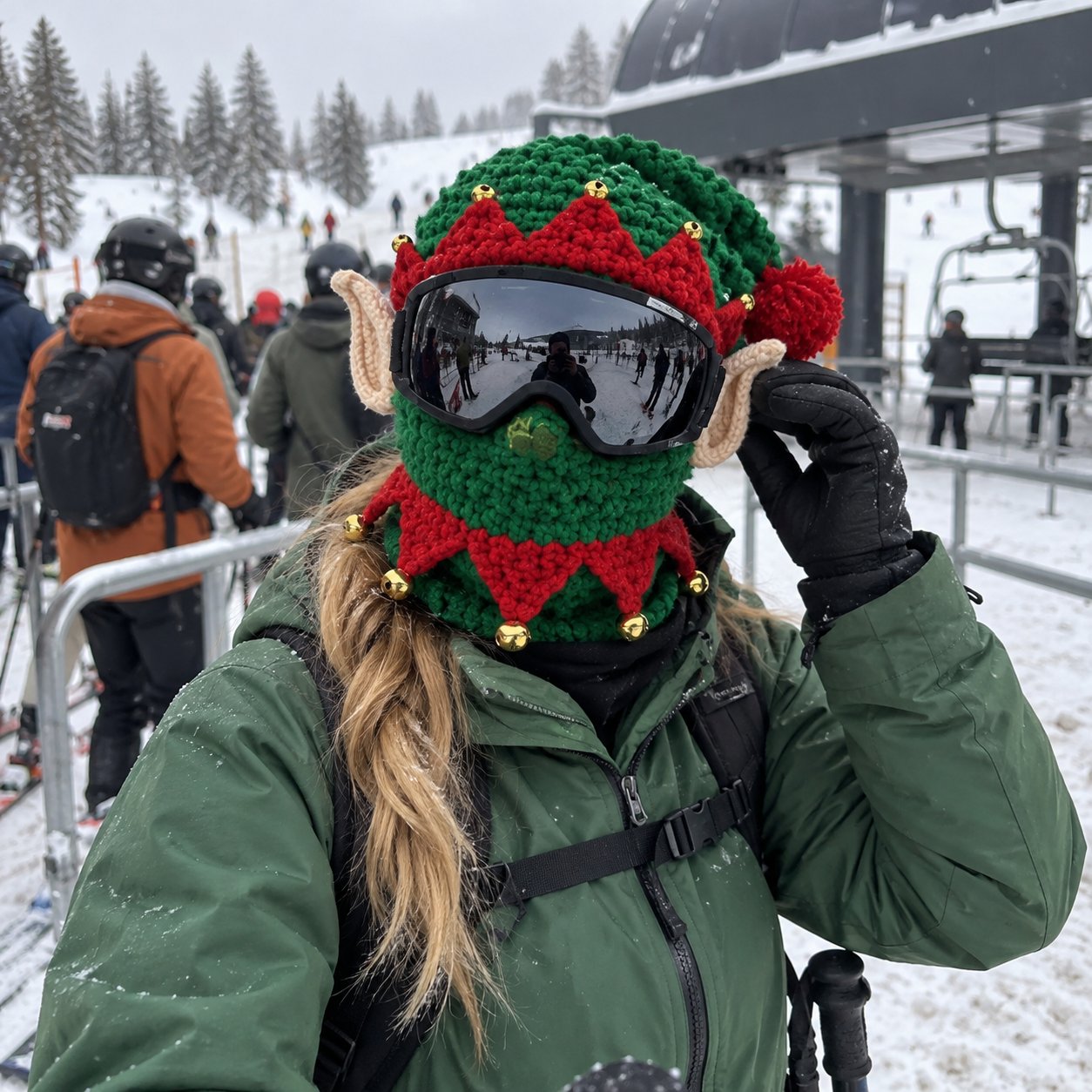 Klantfoto van een groen elfjesmasker met skibril naast een skilift