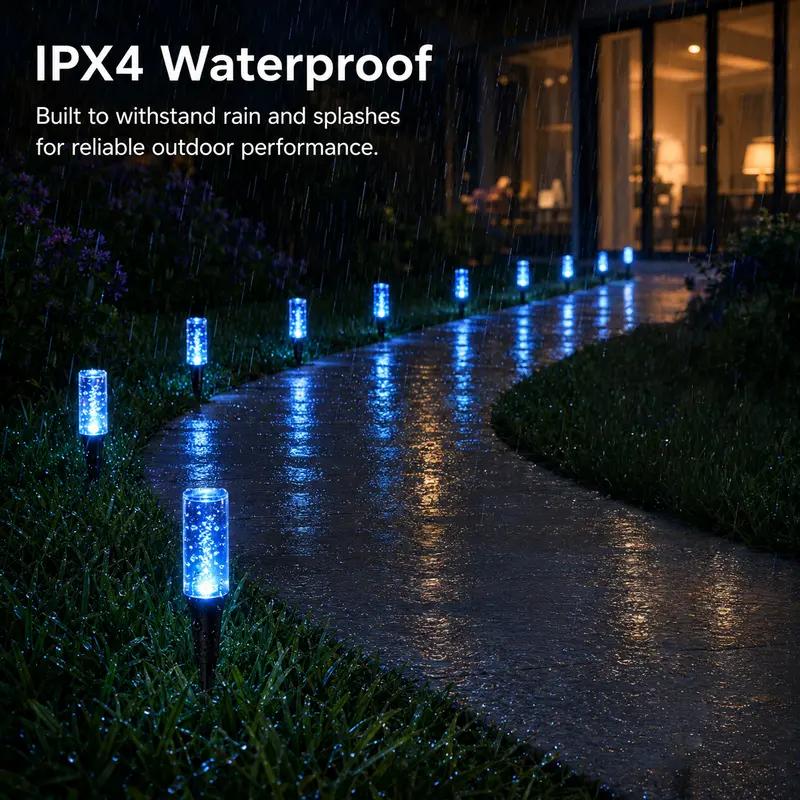 Blue pathway lights glowing in rain beside a wet sidewalk