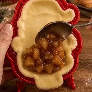 Hands releasing Santa shaped dough from a mold