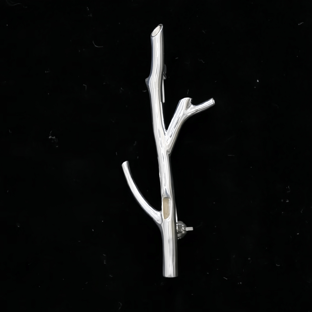 Silver branch brooch alone on a black background